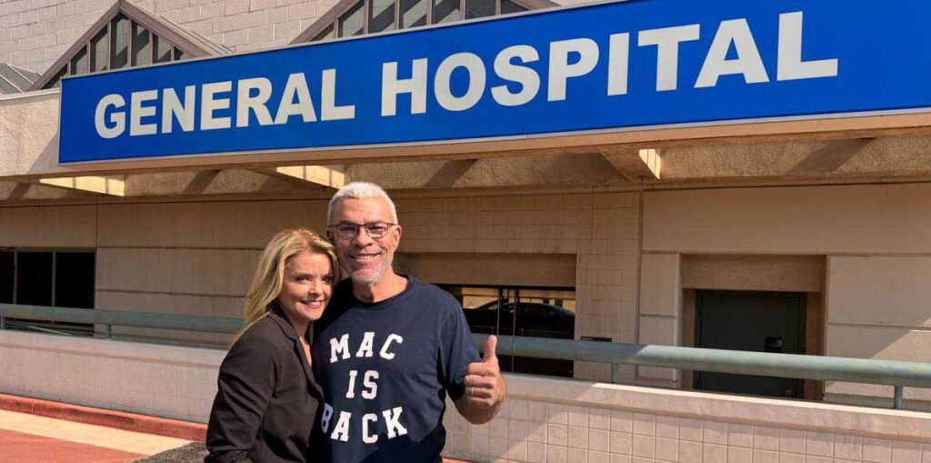 kristina wagner and john j york in front of the general hospital sign.